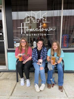 Girls sitting on bench outside of store