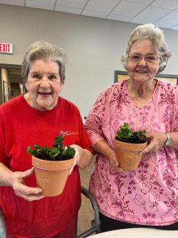Seniors holding flower pots