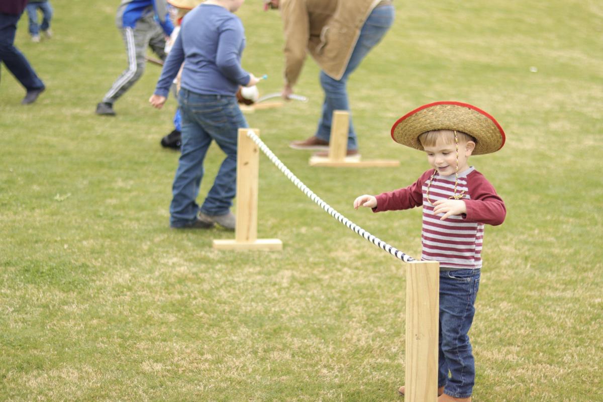 Child in Cowboy Hat Playing in Field
