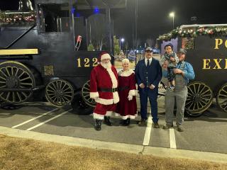 Santa and Ms Claus standing in front of the Polar Express train
